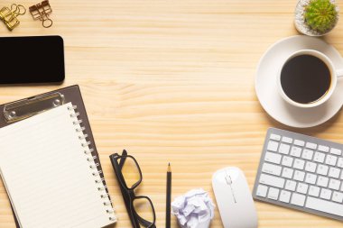 Bilgisayarlı ahşap masa ofisi, akıllı telefon ve bir fincan kahveyle birlikte diğer iş malzemeleri. Metni kopyalamak için üst görünümü kullan. Desenci çalışma alanı düz masa üzerinde temel elementler yatıyordu.