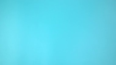 Görüntü 4K. Mavi arka planda pembe kurdele tutan eller. Göğüs kanseri farkındalığı, erkek göğüs kanseri hastalığı, Dünya Kanser Günü. Sağlık hizmetleri ya da hastane ve sigorta kavramı.