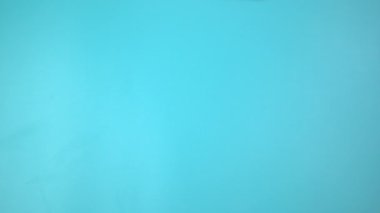 Görüntü 4K. Mavi arka planda pembe kurdele tutan eller. Göğüs kanseri farkındalığı, erkek göğüs kanseri hastalığı, Dünya Kanser Günü. Sağlık hizmetleri ya da hastane ve sigorta kavramı.