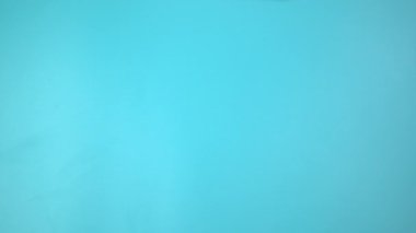 Görüntü 4K. Mavi arka planda pembe kurdele tutan eller. Göğüs kanseri farkındalığı, erkek göğüs kanseri hastalığı, Dünya Kanser Günü. Sağlık hizmetleri ya da hastane ve sigorta kavramı.
