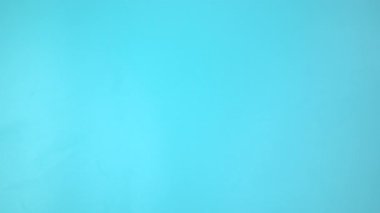 Görüntü 4K. Mavi arka planda deniz mavisi kurdelesini tutan eller... Yumurtalık Kanseri Bilinci, Jinekoloji, Rahim Kanseri, Vulvar Kanseri, Panik Bozukluğu, Travma Sonrası Stres Bozukluğu (PTSD)).