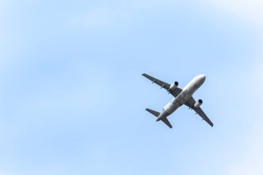 Bulutlar arasında mavi gökyüzünde uçan bir jet uçağı. Ulaşım.