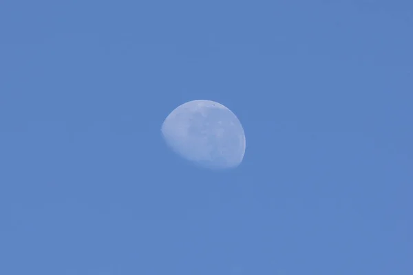 The waning moon in a blue sky. Nature.