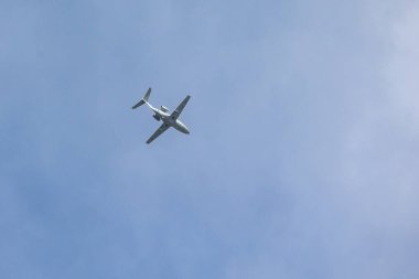 A private jet plane flying in a blue sky between clouds. Transportation. Air travel. Luxury.