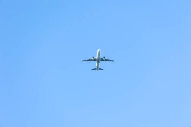 A jet plane flying in a blue sky between clouds. Transportation. Air travel.