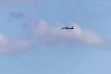 A twin-engine plane flying in a blue sky. Transport. Air travel.