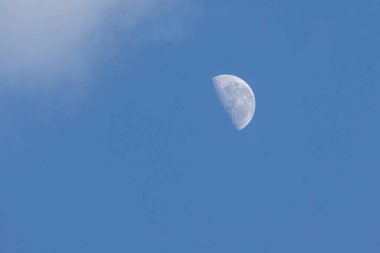Bulutlar arasındaki mavi gökyüzünde ay azalıyor. Doğa göz kamaştırıcı. Astronomi.