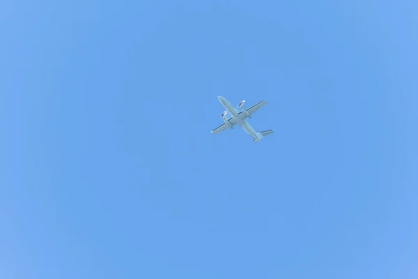 A twin-engine plane flying in a blue sky between clouds. Transportation. Leisure.