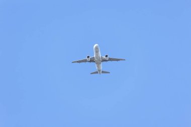 Bulutsuz mavi gökyüzünde uçan bir jet uçağı. Ulaşım. Hava yolculuğu. Boş zaman.