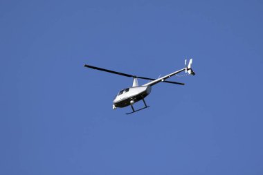 Bir helikopter bulutlarla mavi gökyüzünü geçiyor. Ulaşım. Kentsel.