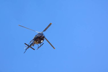 Bir helikopter bulutlarla mavi gökyüzünü geçiyor. Ulaşım. Kentsel.