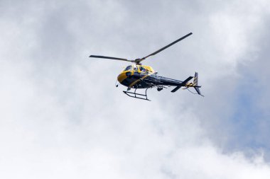 Bir helikopter bulutlarla mavi gökyüzünü geçiyor. Ulaşım. Kentsel.