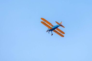 Klasik çift kanatlı uçak. Tek bir motor uçağı mavi gökyüzünü geçer. Ulaşım. Boş zaman. Koleksiyoncu. Klasik..