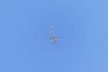 A private jet plane flying in a blue sky between clouds. Transportation. Air travel. Luxury.