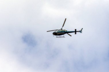 Helikopter bulutlarla mavi gökyüzünü geçiyor. Ulaşım. Kentsel.