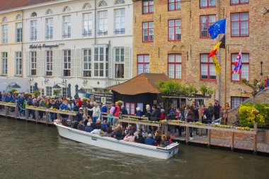 Belçika 'nın Brugge şehrindeki bir kanalda turist teknesi.