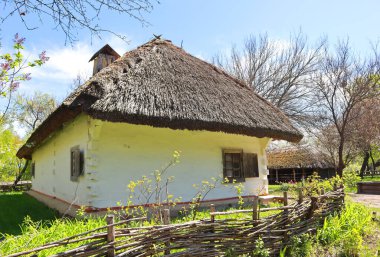 Whitewashed wooden house with a thatched roof from Podolia in skansen Pirogovo in Kyiv, Ukraine