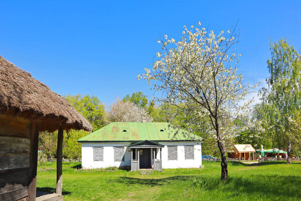 Whitewashed house with a thatched roof from Middle Transnistria in skansen Pirogovo in Kyiv, Ukraine