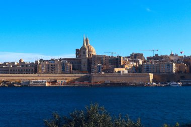 Saint Paul Katedrali 'nin panoramik manzarası ve Malta' nın Sliema kentinden Valletta 'nın antik duvarları.
