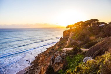 Ponta da Piedade - Lagos, Algarve, Portekiz 'de günbatımında okyanus kıyısında mağaraları ve mağaraları olan ünlü kaya oluşumları