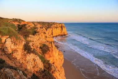 Ponta da Piedade - Lagos, Algarve, Portekiz 'de günbatımında okyanus kıyısında mağaraları ve mağaraları olan ünlü kaya oluşumları