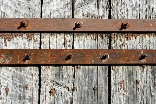Metal bars on a background of light grey old wood planks