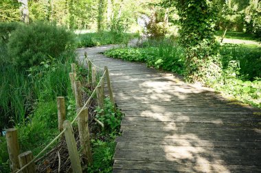 Tahta levhalarda yol, Fransa 'daki Clos Luc şatosunun parkında çapraz geçiş ve kuru çit.