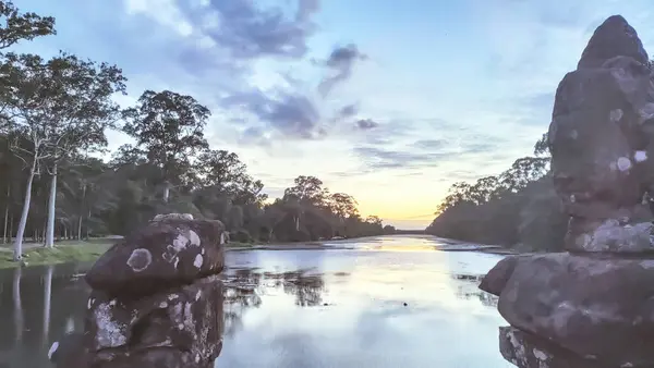 Kayalık bir kıyı şeridi ve arkasında bulutlu bir gökyüzü olan güzel bir göl.