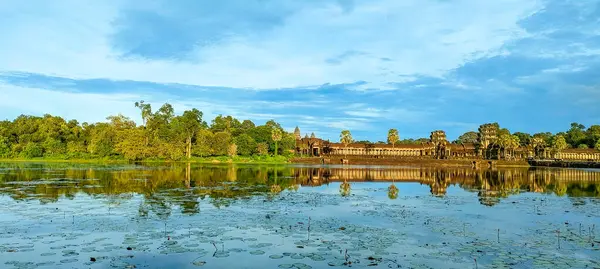 Tarihi tapınak alanındaki sakin sularda altın saat boyunca antik mimarinin çarpıcı yansıması.