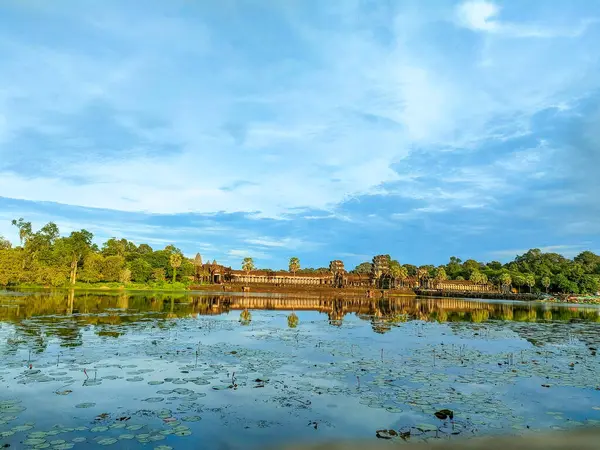 Tarihi tapınak alanındaki sakin sularda altın saat boyunca antik mimarinin çarpıcı yansıması.