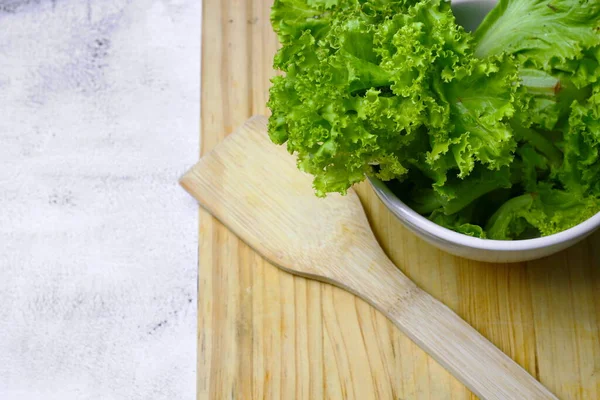 莴苣放在白碗里 在白桌子上放一块刨花板 蔬菜沙拉 干净的食物绿色蔬菜 — 图库照片