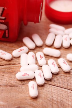 WASHINGTON, ABD - 15 Ekim 2022: Tahta masadaki bir sürü hapla birlikte fazladan Tylenol gücü