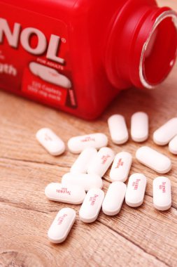 WASHINGTON, ABD - 15 Ekim 2022: Tahta masadaki bir sürü hapla birlikte fazladan Tylenol gücü
