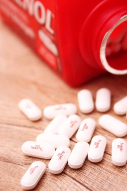 WASHINGTON, ABD - 15 Ekim 2022: Tahta masadaki bir sürü hapla birlikte fazladan Tylenol gücü