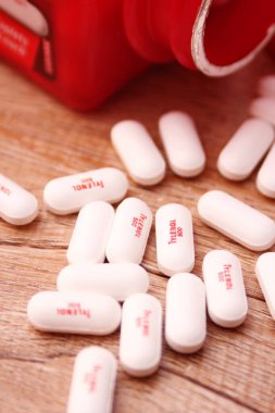 WASHINGTON, ABD - 15 Ekim 2022: Tahta masadaki bir sürü hapla birlikte fazladan Tylenol gücü