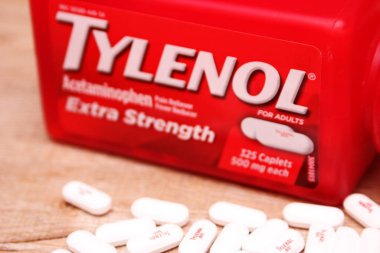 WASHINGTON, ABD - 15 Ekim 2022: Tahta masadaki bir sürü hapla birlikte fazladan Tylenol gücü