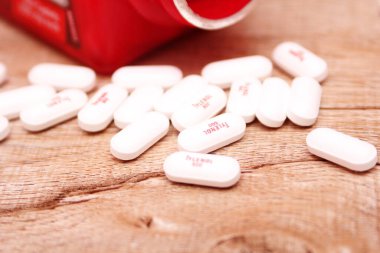 WASHINGTON, ABD - 15 Ekim 2022: Tahta masadaki bir sürü hapla birlikte fazladan Tylenol gücü