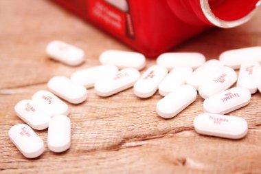 WASHINGTON, ABD - 15 Ekim 2022: Tahta masadaki bir sürü hapla birlikte fazladan Tylenol gücü