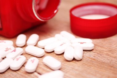 WASHINGTON, ABD - 15 Ekim 2022: Tahta masadaki bir sürü hapla birlikte fazladan Tylenol gücü