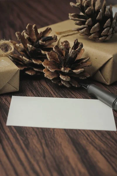 リサイクルされた紙やギフトカード 新年のギフトボックスに包まれたギフトボックス木製のテーブル コピースペース 茶色のクリスマスギフトボックスに置かれます — ストック写真