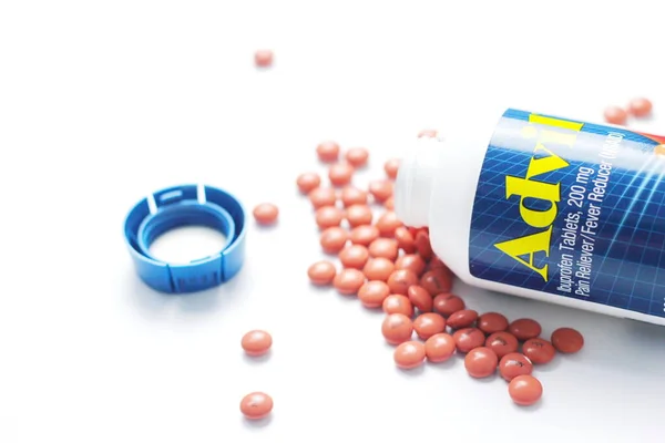 stock image Washington, USA - October 02  2022 : Bottles of advil and pills spread on a white table. Fever, painkiller, popular American painkiller, ibuprofen.