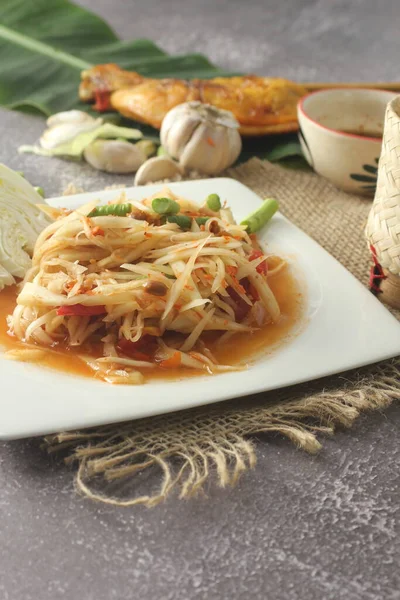 Papaya Salatası, popüler Tayland yemeği ızgara tavuk, yapışkan pirinç ve uzun fasulye ile servis edilir..