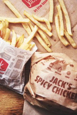 WASHINGTON, USA - January 14, 2023 : A home-style rance chiken club burger or Jack Spicy Chicken Burger served on a wooden table in a jack in the box restaurant in the USA.