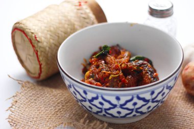 Baharatlı Kızarmış Yayın Balığı Tayland usulü beyaz bir masada servis edilir..