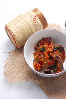 Baharatlı Kızarmış Yayın Balığı Tayland usulü beyaz bir masada servis edilir..