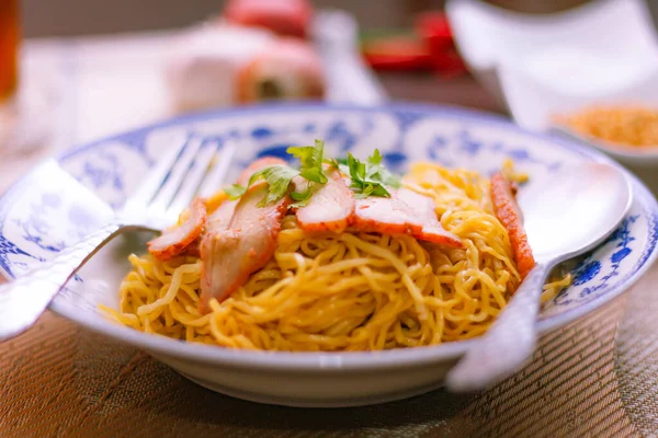 stock image Egg Noodles with Barbeque Pork in Chinese Style Plates on a Wooden Table with Tea and