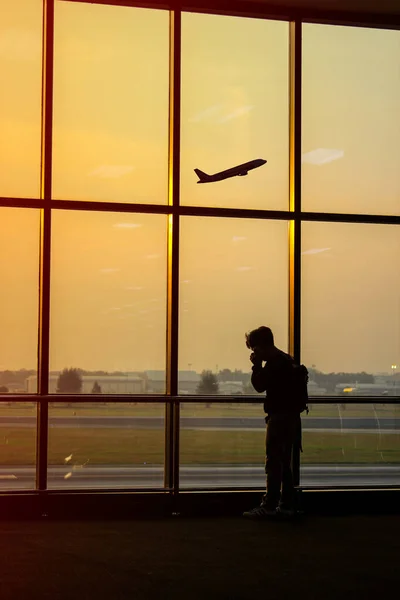 Silhouette of a man at the airport with an airplane in the background