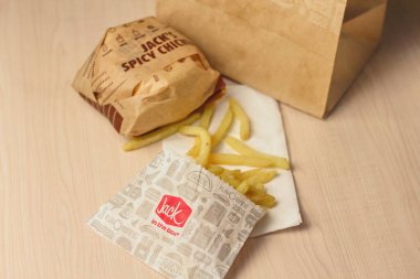 WASHINGTON, ABD - 10 Ocak 2023: Ev usulü Rance Chiken Club Burger ya da Jack Spicy Chicken Burger, ABD 'deki kutu restoranında ahşap bir masada servis edildi..