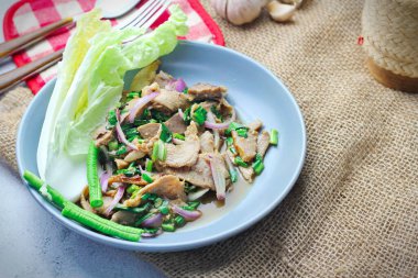 Dilimlenmiş sığır eti salatası, Tayland 'da Isaan yemeği, Tayland' da yerel yemek. Uzun fasulye ve marulla servis edilir Gri bir tabakta Tayland restoranında servis edilir.