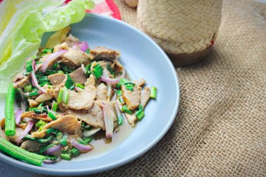 Dilimlenmiş sığır eti salatası, Tayland 'da Isaan yemeği, Tayland' da yerel yemek. Uzun fasulye ve marulla servis edilir Gri bir tabakta Tayland restoranında servis edilir.